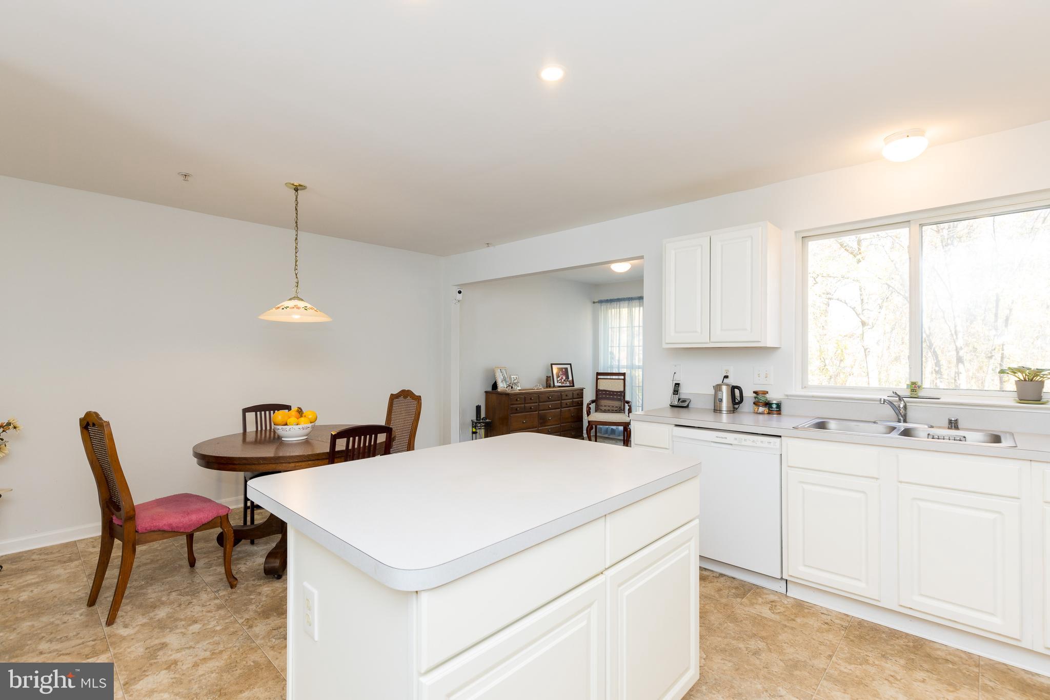 232 Night Haven Court Edgewater, MD 21037 - Photo 29 of 39 a kitchen with a stove a sink a dining table and chairs