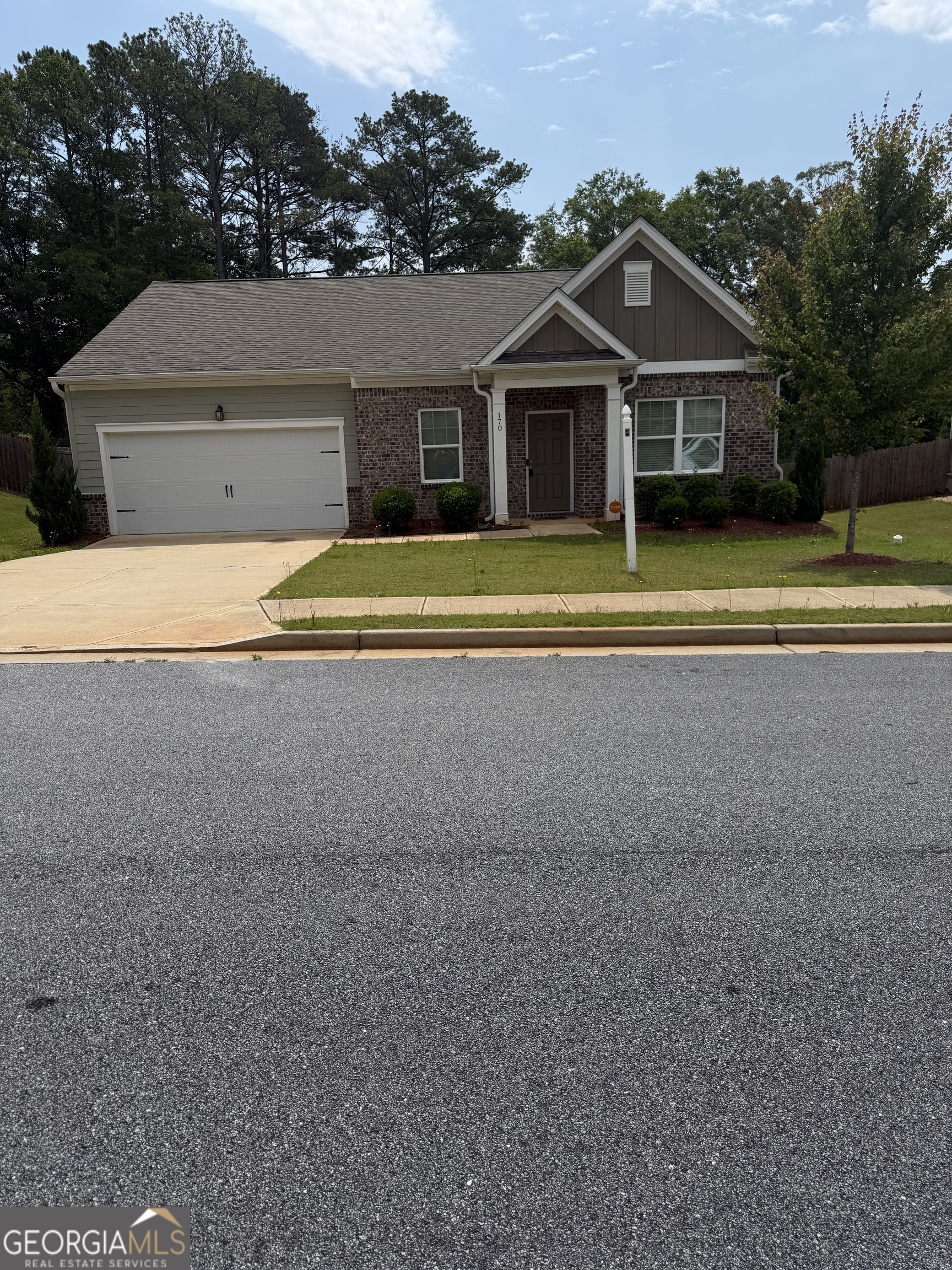 a view of house with a yard and potted plants