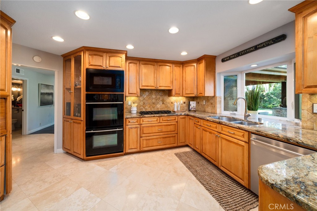25695 La Cima Laguna Niguel, CA 92677 - Photo 11 of 52 a large kitchen with stainless steel appliances kitchen island granite countertop a refrigerator and a stove top oven