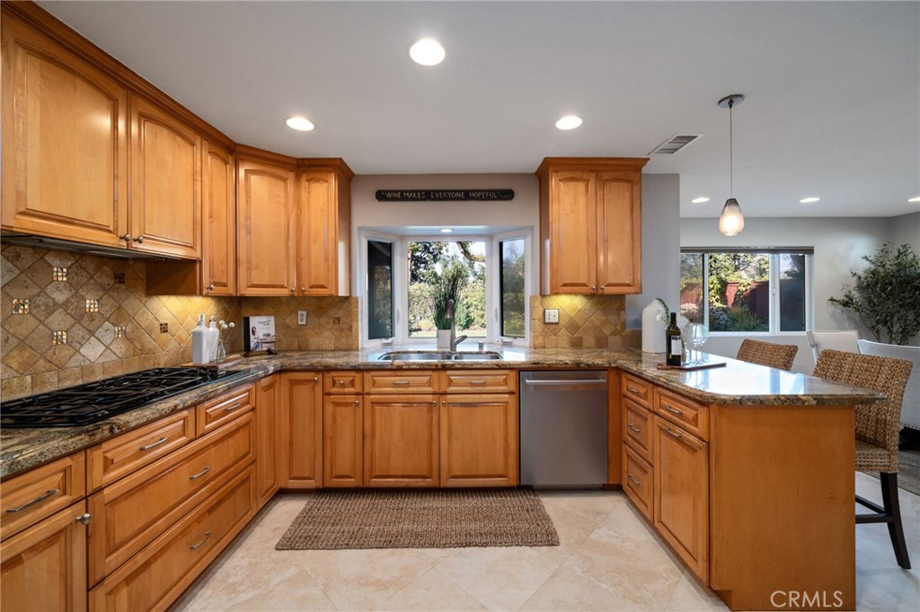 25695 La Cima Laguna Niguel, CA 92677 - Photo 10 of 52 a kitchen with kitchen island granite countertop a sink stove and cabinets