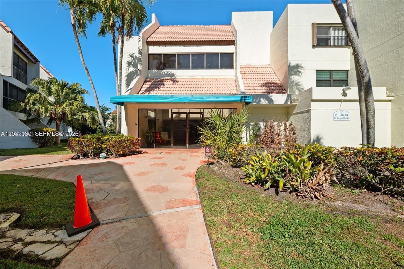 301 Racquet Club Road, Unit 104 Weston, FL 33326 - Photo 17 of 21 a front view of a house with a yard