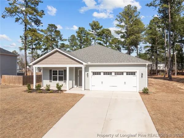 a kitchen with stainless steel appliances granite countertop a sink stove a refrigerator and white cabinets with wooden floor