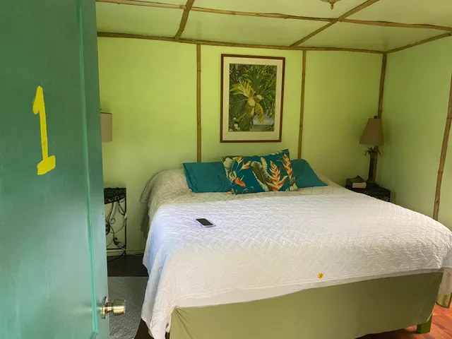 a bedroom with a bed and painting on the wall
