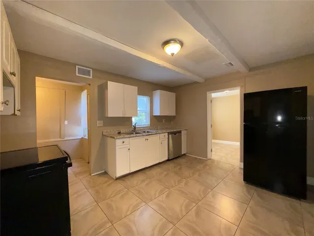 a large kitchen with a stove a sink and a refrigerator