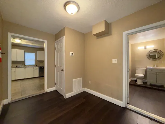 a view of a room that has a large mirror and sink