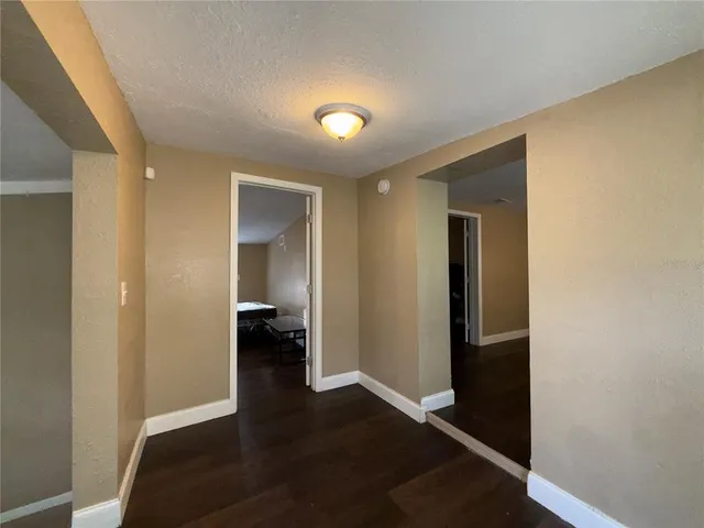 a view of a hallway with wooden floor and closet