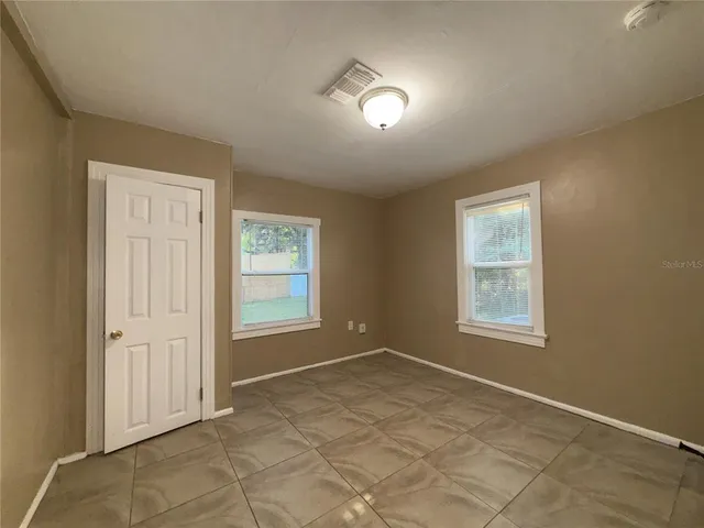 an empty room with windows and closet