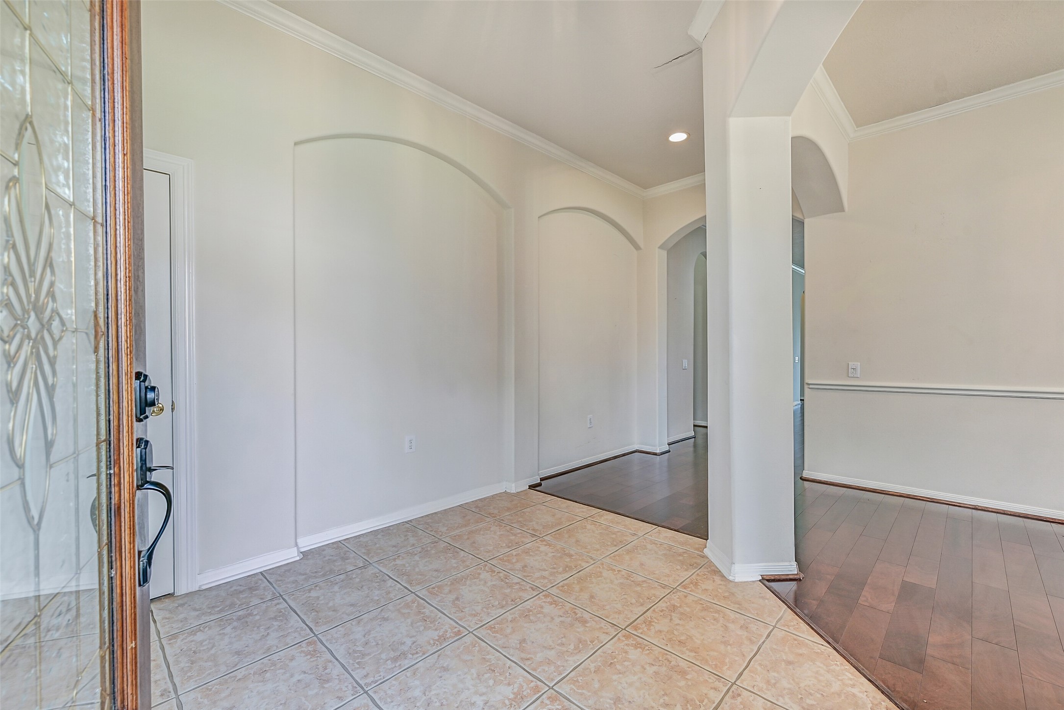 1448 North Riviera Circle Pearland, TX 77581 - Photo 3 of 35 Step inside through a beautiful wooden front door with beveled glass inlay. The welcoming entry features art niches and space for a console or entry table, creating a warm first impression as you enter the home.