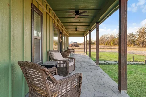 a patio with yard glass top table and sofas