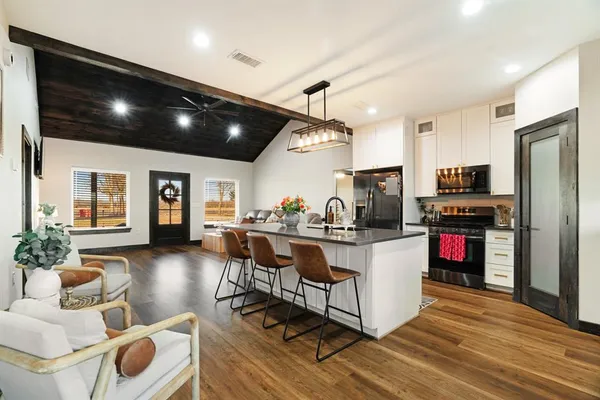 a kitchen with stainless steel appliances kitchen island granite countertop a refrigerator and a stove top oven