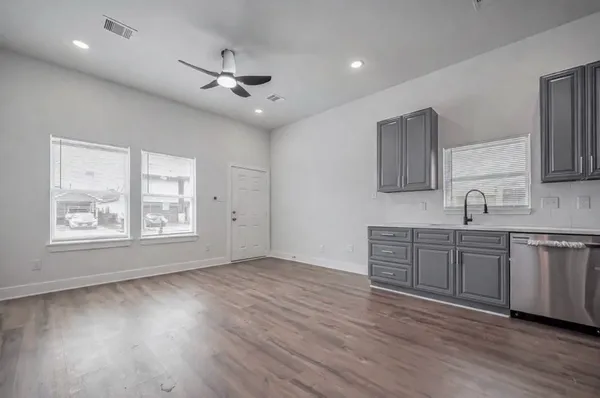 a view of a kitchen with a sink dishwasher and wooden floor