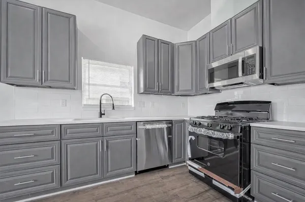 a kitchen with stainless steel appliances granite countertop a stove and a microwave