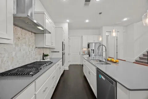a kitchen with stainless steel appliances a sink stove and cabinets
