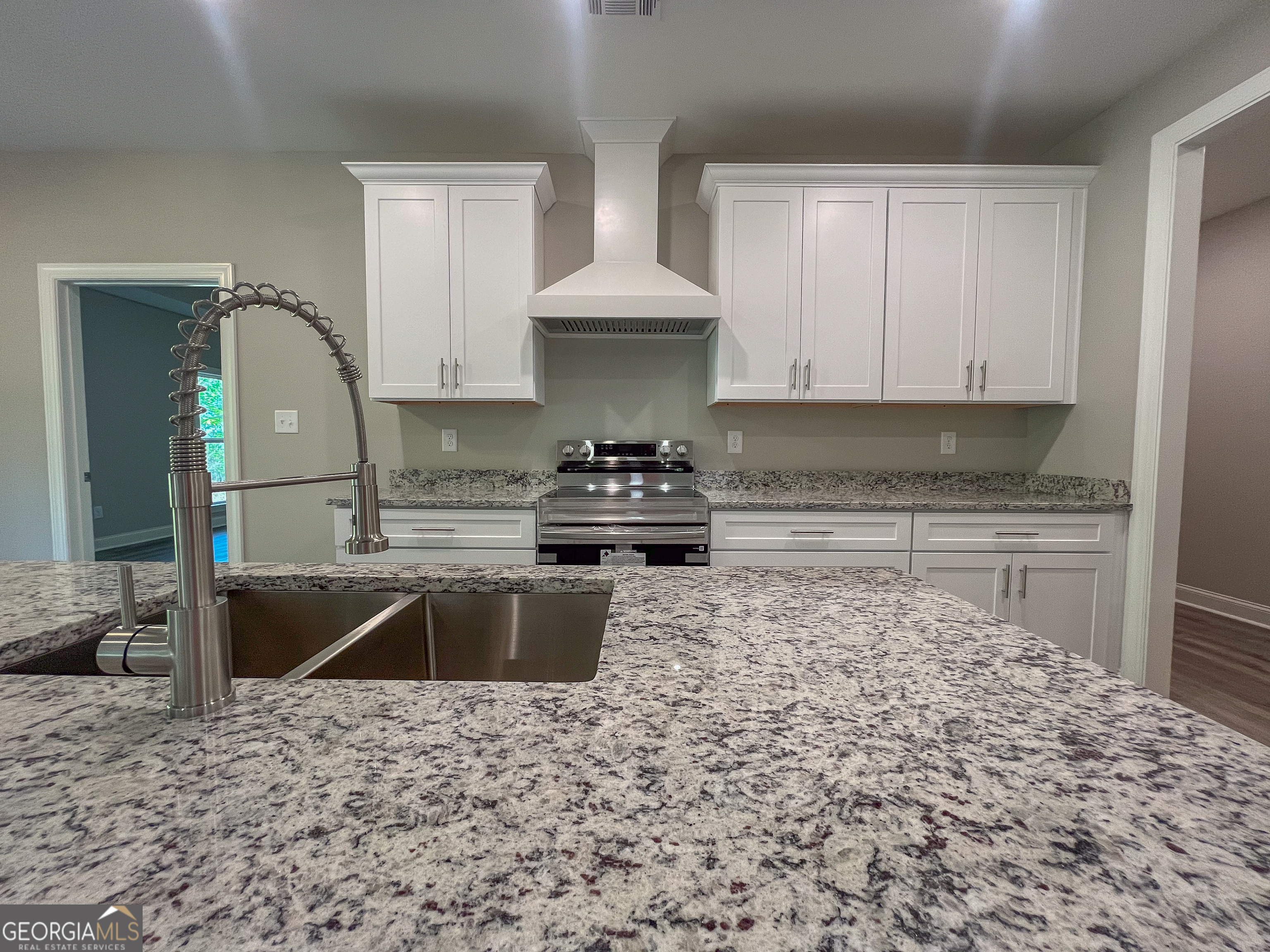 711 Flanders Lane Dublin, GA 31021 - Photo 12 of 49 a kitchen with granite countertop a sink stove and refrigerator