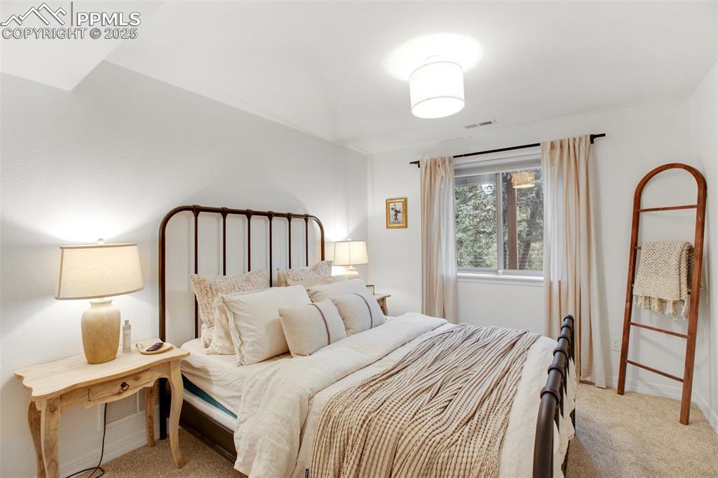 277 Aspen Circle Divide, CO 80814 - Photo 27 of 45 a bedroom with a bed a mirror and a window