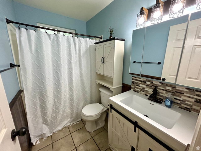 441 South 400 East Payson, UT 84651 - Photo 21 of 39 Bathroom featuring a vanity with an integrated white sink, a mosaic tile backsplash, and a wall-mounted light fixture with wire cages
