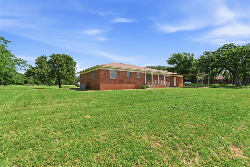 3523 East Highway 199 Springtown, TX 76082 - Photo 6 of 40 Expansive green lawn surrounding a brick single-story residence