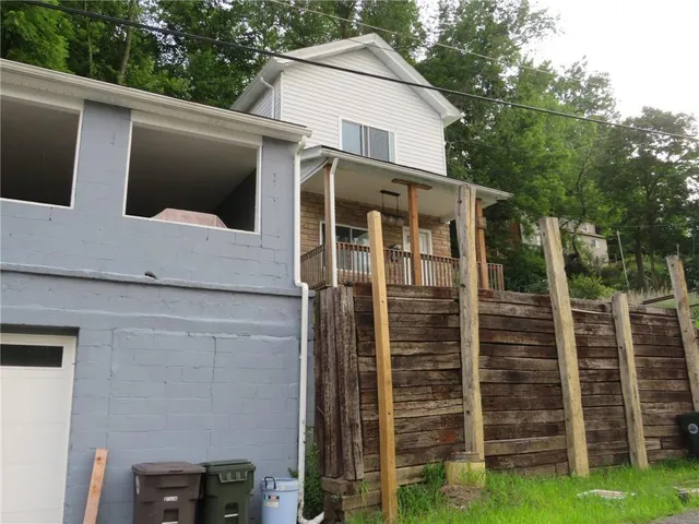 a view of a house with a window and wooden fence