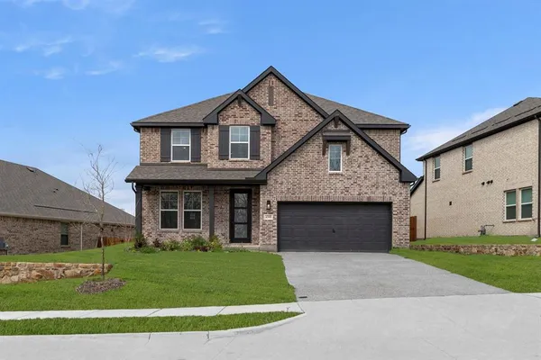 a front view of a house with a garden and yard