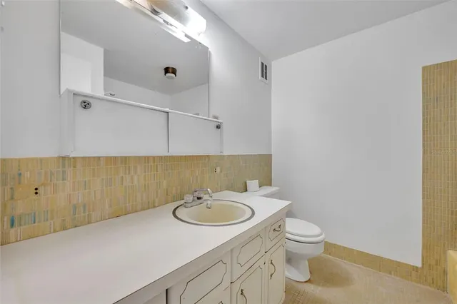 a bathroom with a sink a toilet and mirror