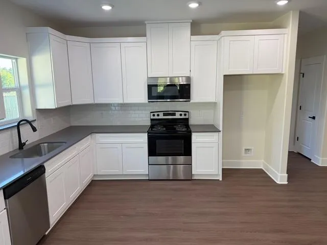 a kitchen with a sink a stove and cabinets