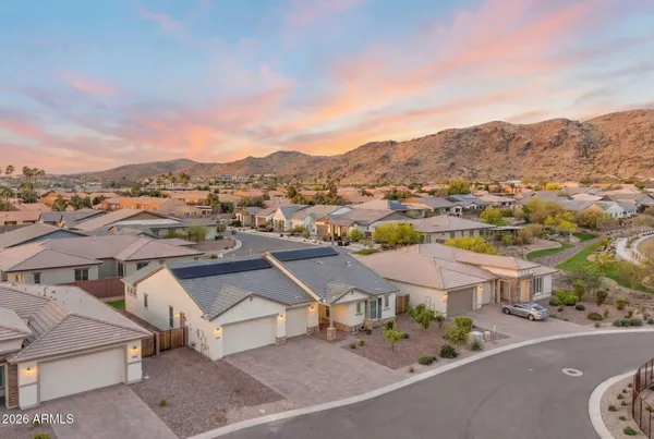 a view of a house with a yard and large tree
