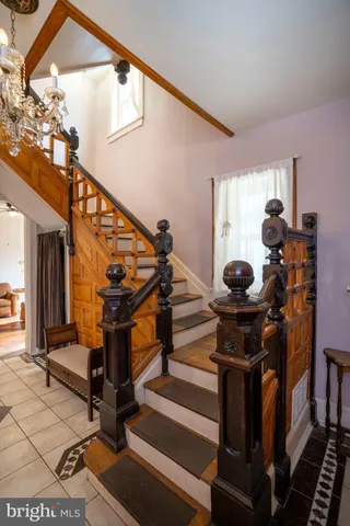 a living room with furniture two large windows next to a dining table and chairs with wooden floor