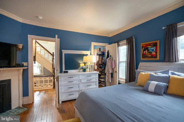 a bedroom with a bed dresser and wooden floor