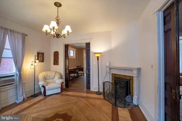 a dining room with wooden floor a chandelier a wooden table and chairs