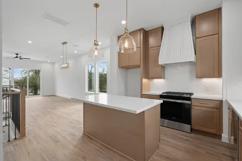 a kitchen with stainless steel appliances granite countertop a stove a sink and a refrigerator