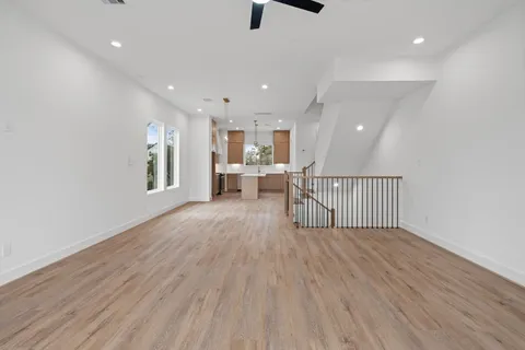 a view of a hallway with wooden floor and a window