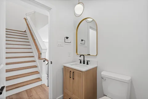 a bathroom with a sink and mirror with toilet