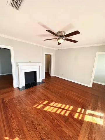 a view of empty room with wooden floor and fireplace