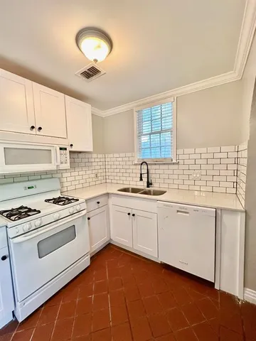 a kitchen with granite countertop a stove sink and cabinets