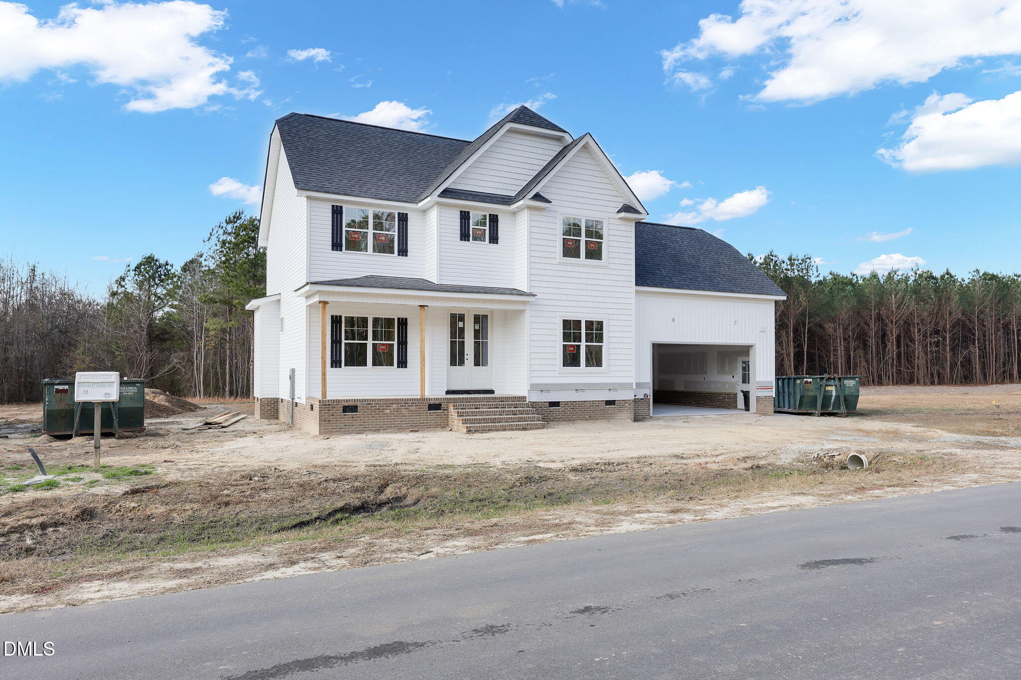 a front view of a house with a dirt yard and a garage