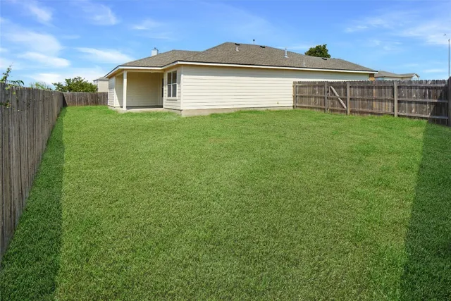 a view of a backyard with wooden fence