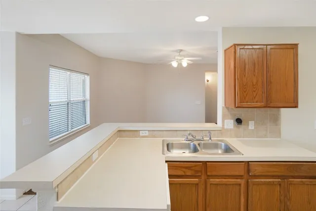 a large white kitchen with a sink a stove and a refrigerator