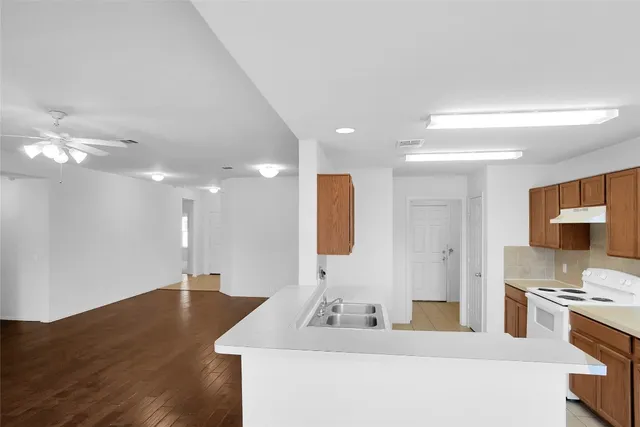 a kitchen with a sink a stove and a refrigerator