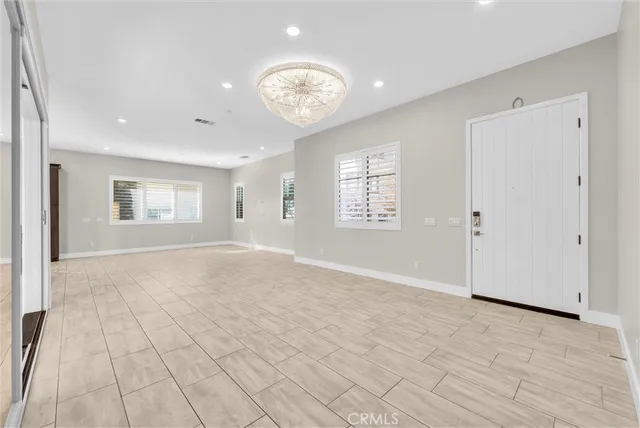 an empty room with entrance and windows