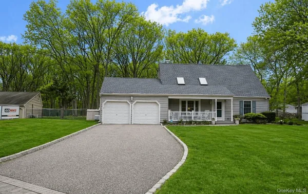 a front view of a house with a yard and trees