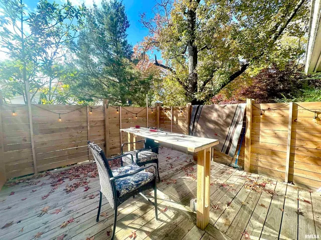 a view of a patio with table and chairs with wooden fence and floor
