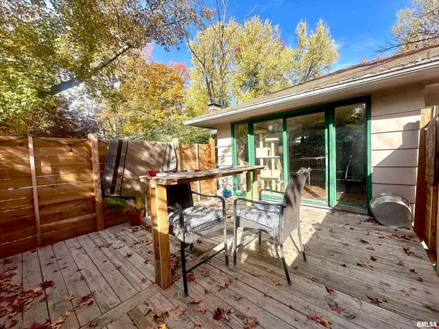 a view of a patio with table and chairs with wooden floor and fence