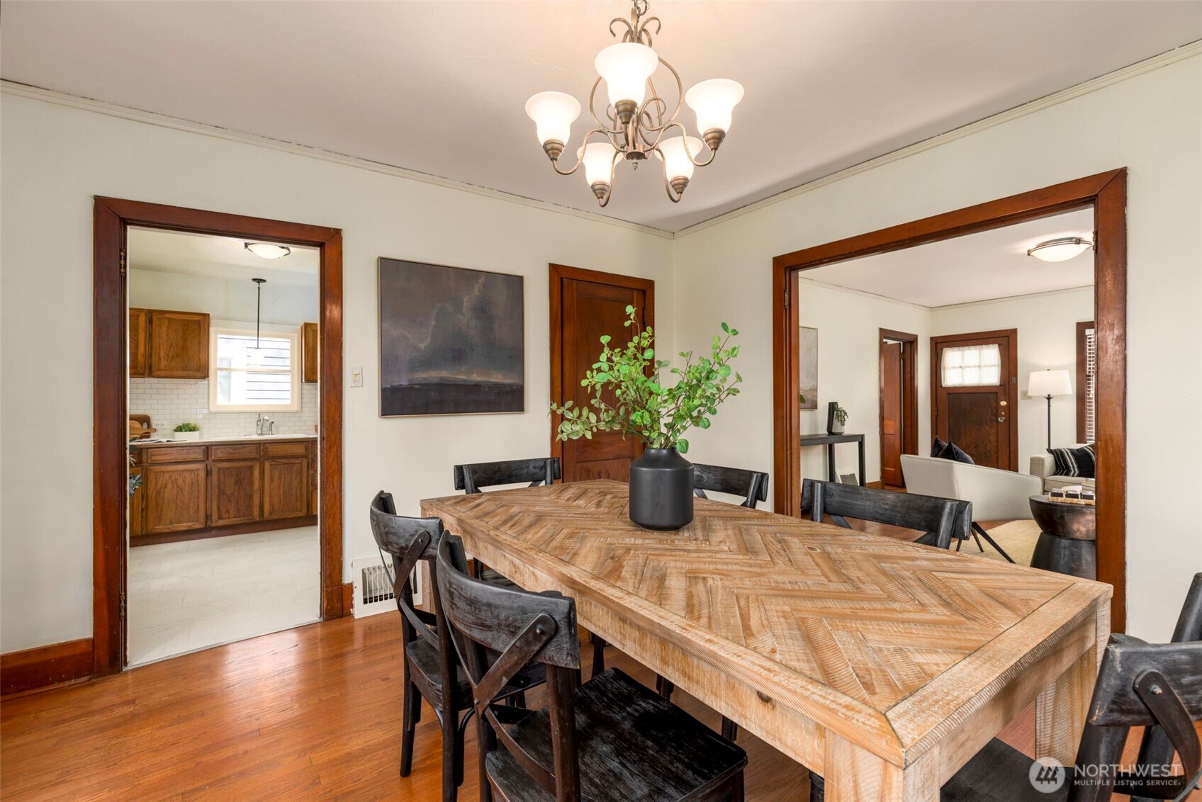 1815 29th Avenue South Seattle, WA 98144 - Photo 9 of 25 a dining room with wooden floor a chandelier a wooden table and chairs
