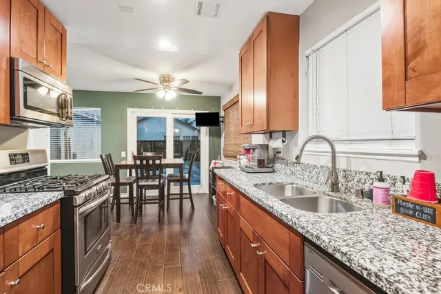 a kitchen with granite countertop a sink stove and cabinets