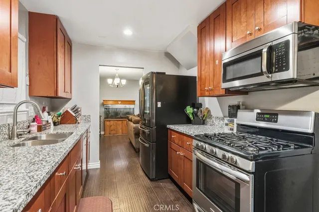 a kitchen with stainless steel appliances granite countertop a stove a sink dishwasher and a refrigerator