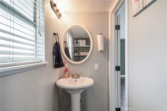 a bathroom with a sink a mirror and a window