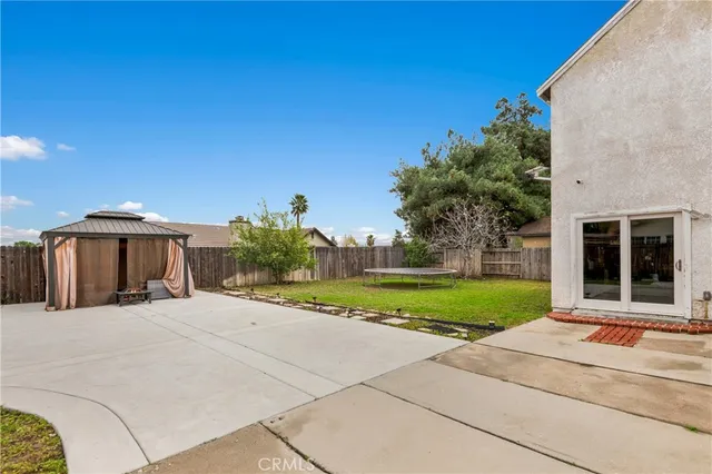 a view of a house with backyard and trees