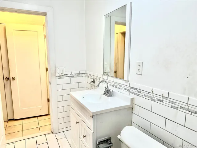 a bathroom with a sink mirror vanity and toilet