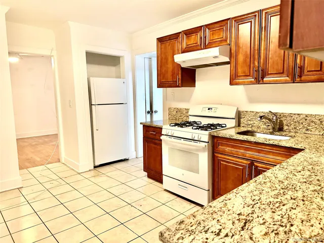 a kitchen with stainless steel appliances granite countertop a stove a sink and a refrigerator