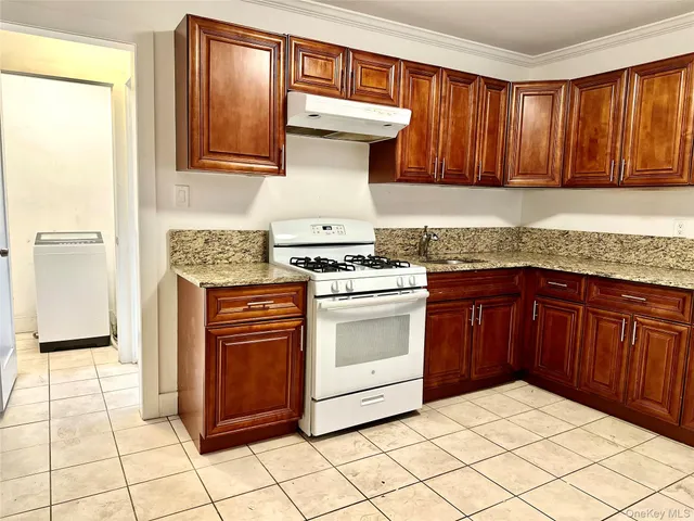 a kitchen with stainless steel appliances granite countertop a stove a sink and a microwave